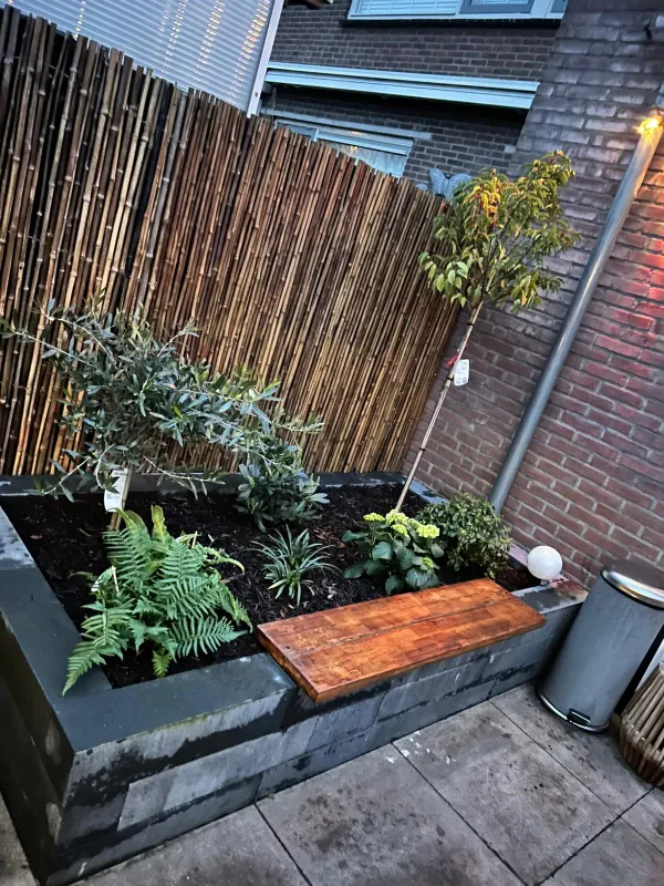 Bloembak met planten en bamboe schutting 