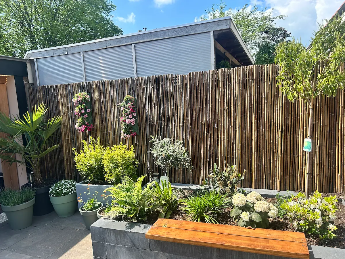 Bloembak met planten en bamboe schutting