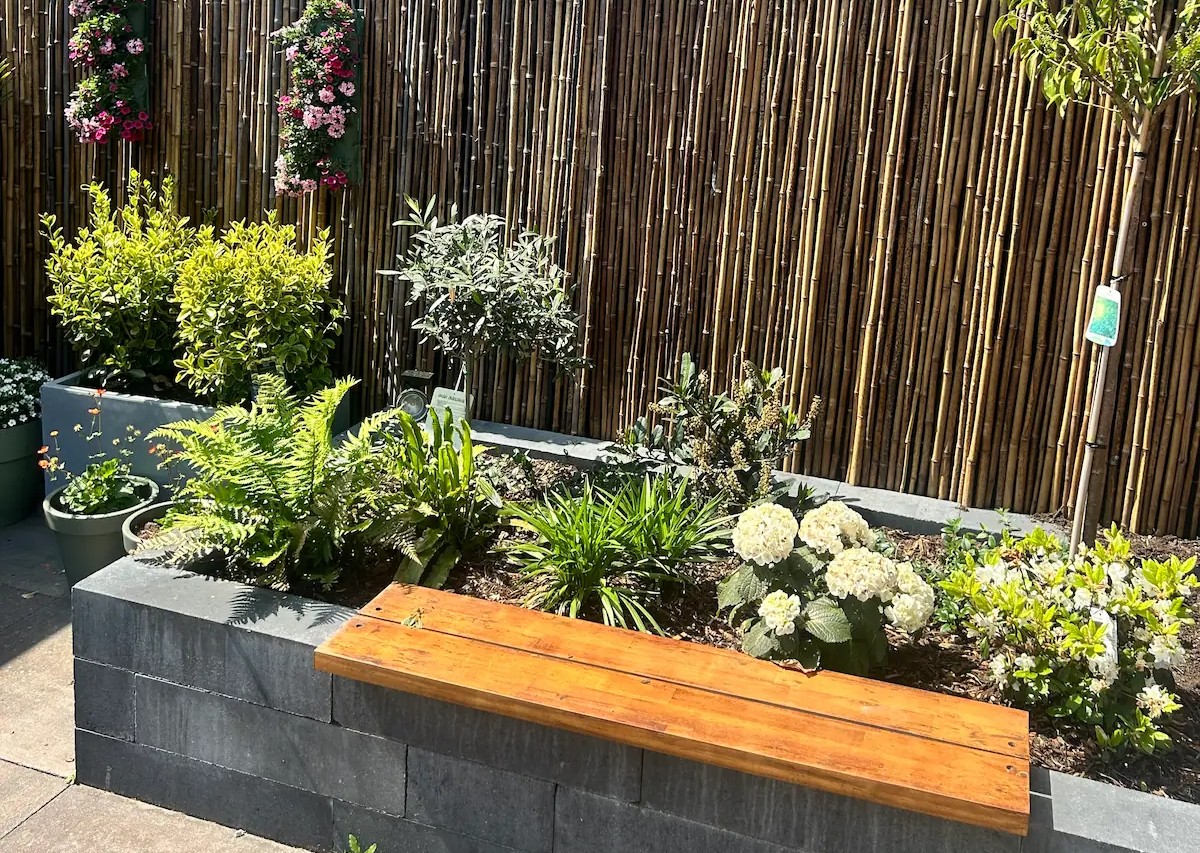Bloembak met planten en bamboe schutting